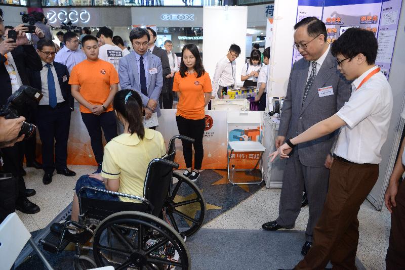 The Secretary for Innovation and Technology, Mr Nicholas W Yang (second right), watches a demonstration of the iWheel device invented by students of Buddhist Wong Wan Tin College at the Project WeCan x HKUST STEAM Expo today (July 6). A manual wheelchair installed with iWheel at its bottom part will work as an electric wheelchair.