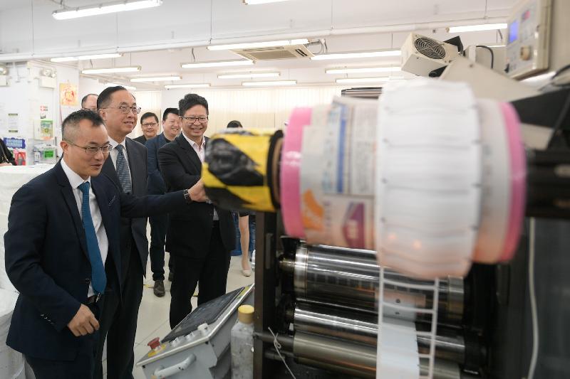 The Secretary for Innovation and Technology, Mr Nicholas W Yang (centre), takes a tour of the automated production lines of a radio frequency identification label and hangtag manufacturing company during his visit to Kwai Tsing District today (October 5). Next to Mr Yang is the Chairman of the Kwai Tsing District Council, Mr Law King-shing (right).