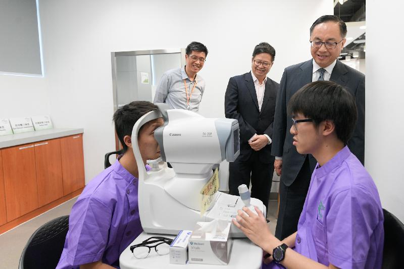 The Secretary for Innovation and Technology, Mr Nicholas W Yang (back row, right), watches students receiving training at the HealthTech Centre of the Hong Kong Institute of Vocational Education (Kwai Chung) today (October 5). Looking on is the Chairman of the Kwai Tsing District Council, Mr Law King-shing (back row, centre).
