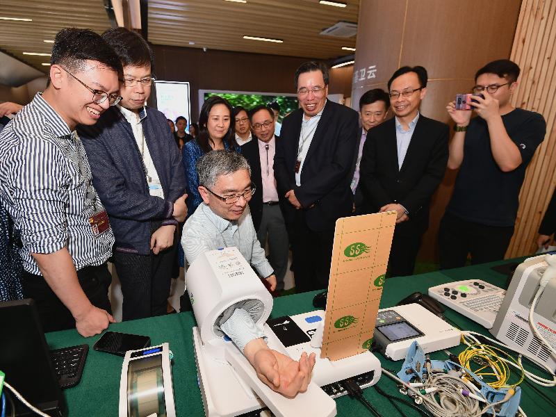The Secretary for Financial Services and the Treasury, Mr James Lau (third left), tries out services available at WeDoctor in Hangzhou today (April 24). Looking on are the Secretary for Constitutional and Mainland Affairs, Mr Patrick Nip (second right), and the Secretary for Innovation and Technology, Mr Nicholas W Yang (fourth right).