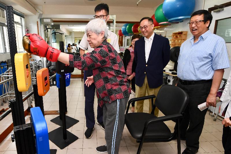 The Secretary for Innovation and Technology, Mr Nicholas W Yang (second right), views the operation of an interactive training system funded by the Innovation and Technology Fund for Application in Elderly and Rehabilitation Care during his visit to the Buddhist Li Ka Shing Care and Attention Home for the Elderly today (May 27). Looking on is the Chairman of the Wan Chai District Council, Mr Stephen Ng (first right).