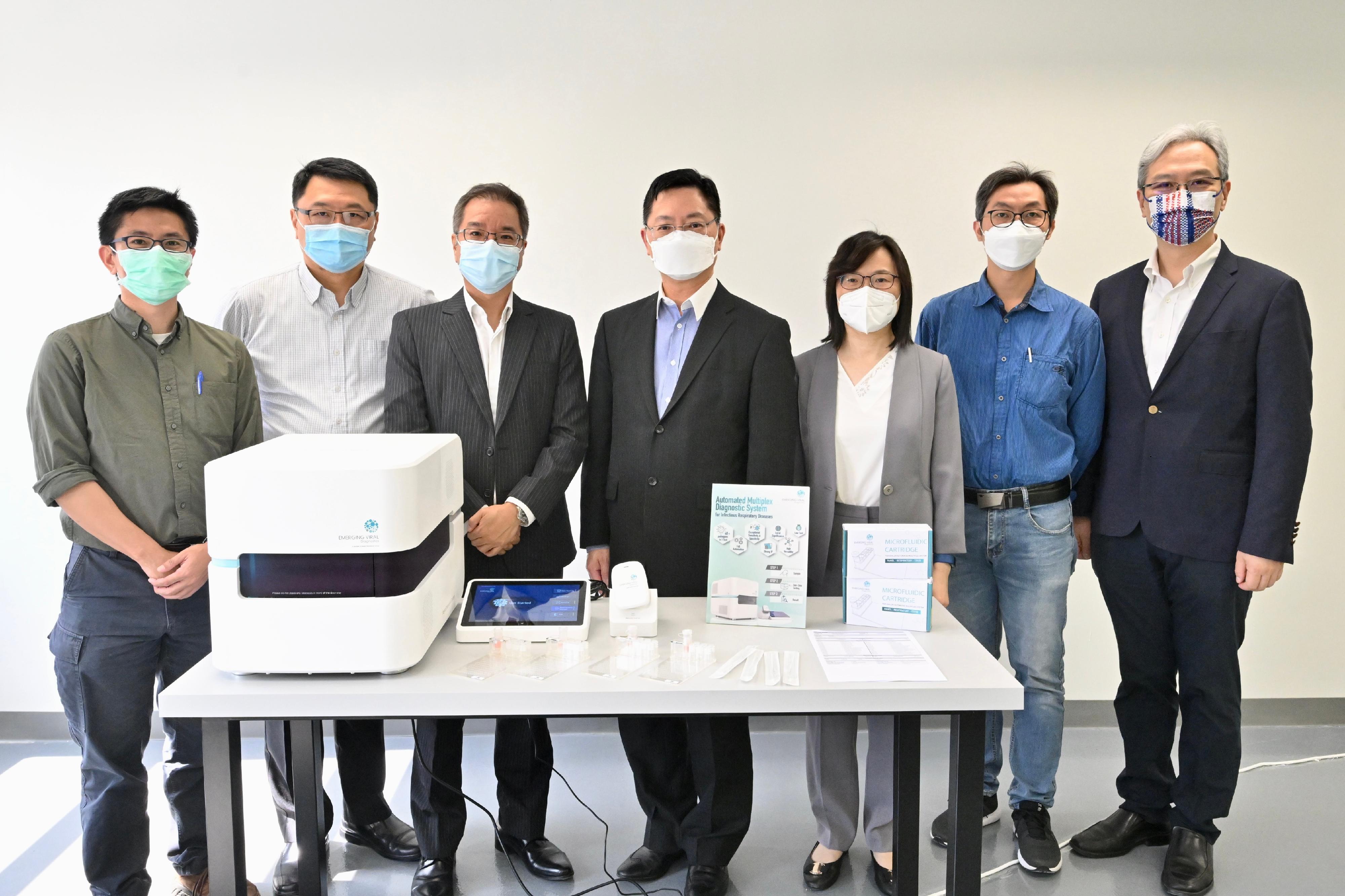 The Secretary for Innovation and Technology, Mr Alfred Sit (centre), and the Commissioner for Innovation and Technology, Ms Rebecca Pun (third right), inspect the Innovative, Automated Multiple Point-of-Care Diagnostic Systems of an enterprise located in the MARS Centre today (May 5). The System can detect the pathogens of up to 40 infectious respiratory diseases, including the COVID-19 virus and severe acute respiratory syndrome coronavirus, in a single test in around an hour. Looking on is the Chairman of the Board of Directors of the Hong Kong Science and Technology Parks Corporation, Dr Sunny Chai (second left).